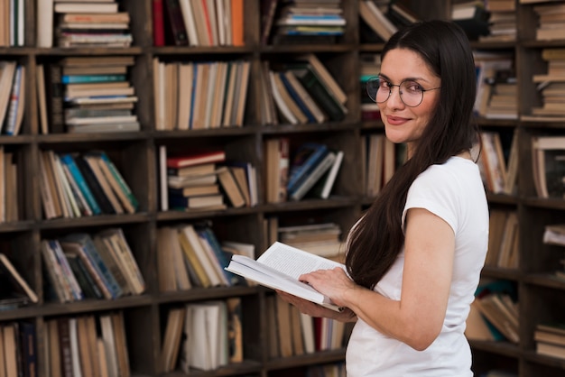 Ritratto di bella donna che posa con il libro