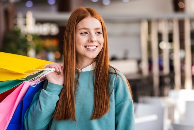 Ritratto di bella donna che tiene i sacchi di carta variopinti