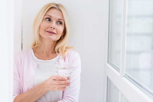 Ritratto di bella donna che tiene un bicchiere d'acqua