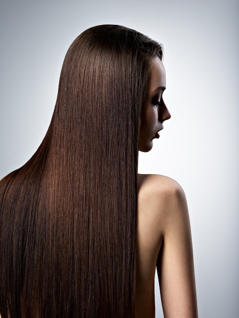 Ritratto di bella donna con capelli castani lunghi dritti in studio