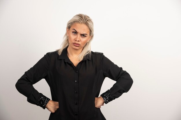 Ritratto di bella donna in camicia nera in posa su sfondo bianco. Foto di alta qualità