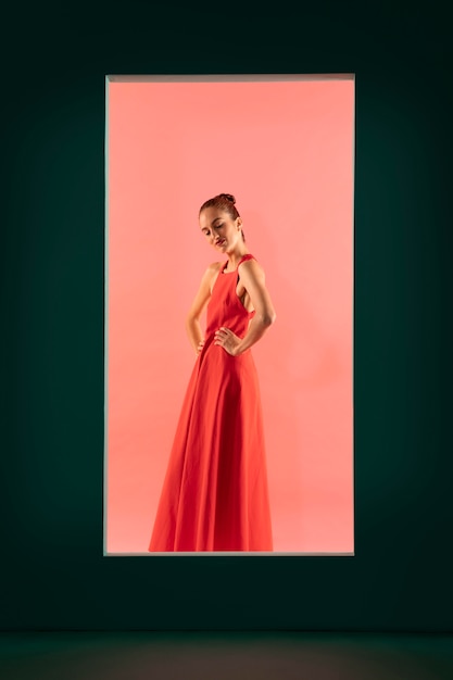 Ritratto di bella donna in posa con un vestito rosso fluido