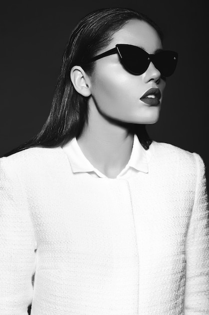 Ritratto di bella giovane donna alla moda con gli occhiali da sole
