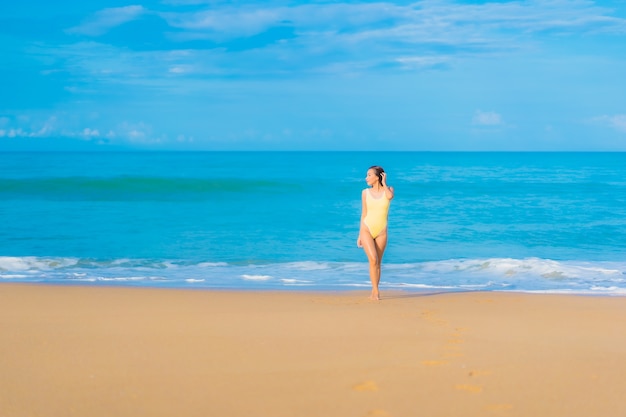 Ritratto di bella giovane donna asiatica che si rilassa in spiaggia in vacanza di viaggio