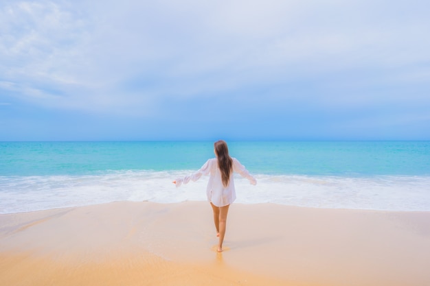 Ritratto di bella giovane donna asiatica che si rilassa intorno all'oceano del mare della spiaggia nella vacanza di viaggio