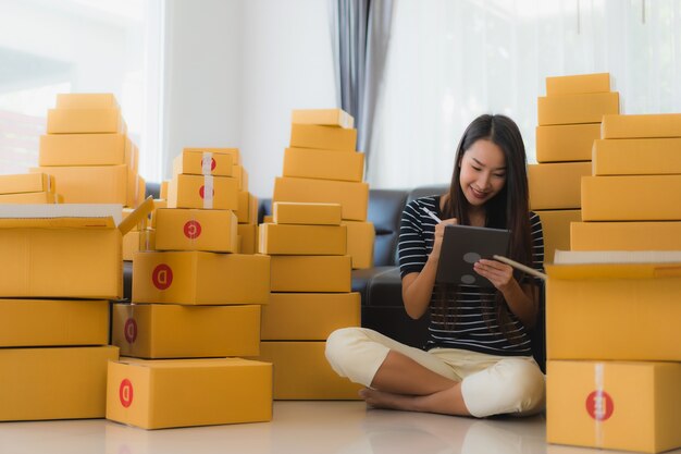 Ritratto di bella giovane donna asiatica con scatole di pacchi di cartone