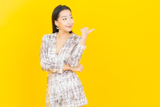 Ritratto di bella giovane donna asiatica sorriso in posa su yellow