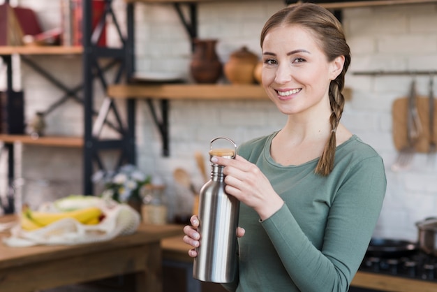 Ritratto di bella giovane donna che tiene thermos