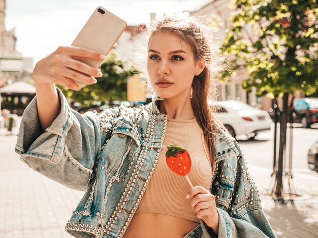 Ritratto di bella modella carina in vestiti di giacca di jeans hipster estivi