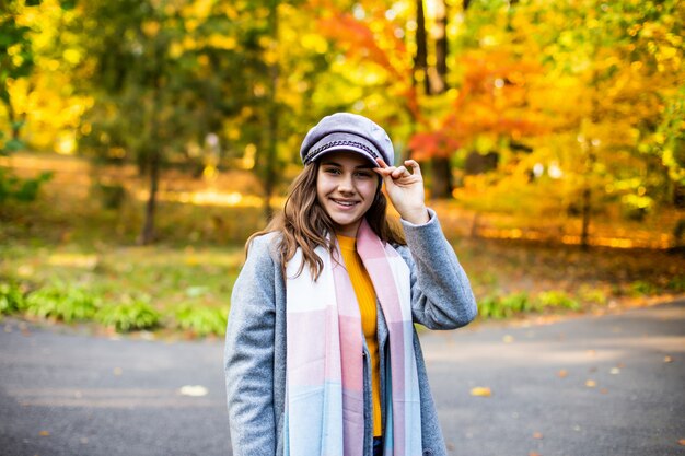 Ritratto di bella ragazza che cammina per strada in autunno.