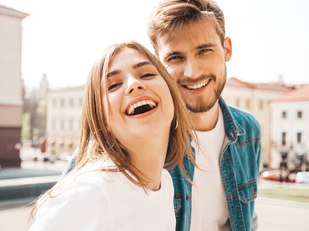 Ritratto di bella ragazza sorridente e il suo bel ragazzo in abiti estivi casual. . Abbracciare