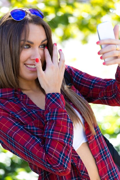 Ritratto di bella ragazza utilizzando il suo telefono cellulare in città.