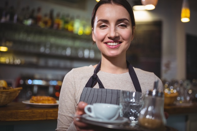 Ritratto di cameriera azienda tazza di caffè