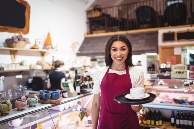 Ritratto di cameriera che serve una tazza di caffè