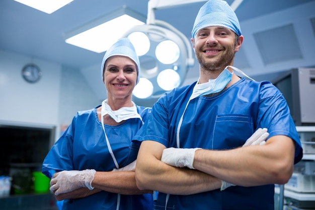 Ritratto di chirurghi in piedi con le braccia incrociate in sala operatoria