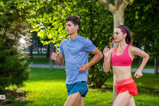 Ritratto di coppia caucasica allegra che corre all'aperto. Famiglia sportiva