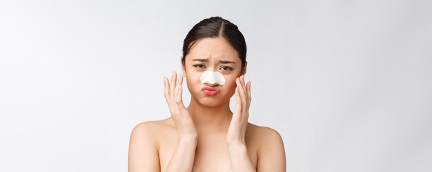 Ritratto di cosmetologia di bella modella asiatica femminile con maschera sul naso Primo piano di una giovane donna sana con pelle morbida pura e trucco naturale fresco