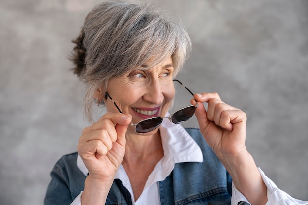 Ritratto di donna anziana sorridente con occhiali da sole