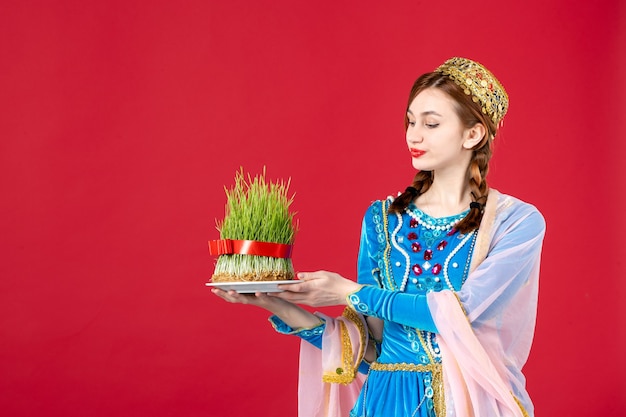 Ritratto di donna azera in abito tradizionale con semeni su rosso