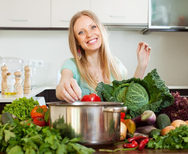 Ritratto di donna bionda felice con le verdure