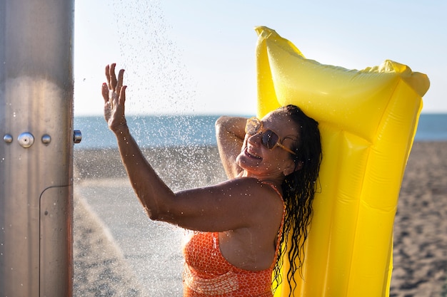 Ritratto di donna che fa la doccia sulla spiaggia