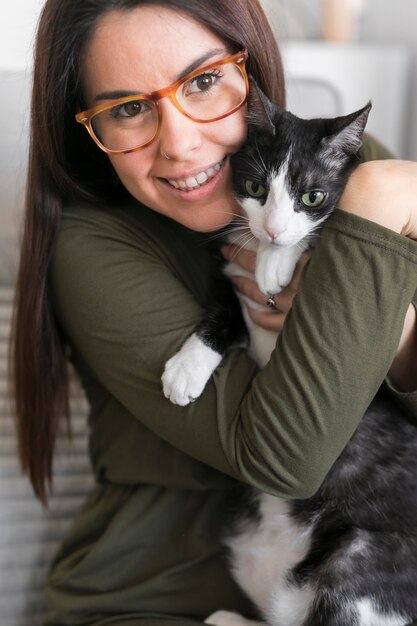 Ritratto di donna che gioca con il gatto seduto sulla sedia