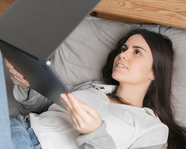 Ritratto di donna che lavora al computer portatile a letto
