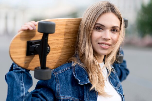 Ritratto di donna che tiene uno skateboard