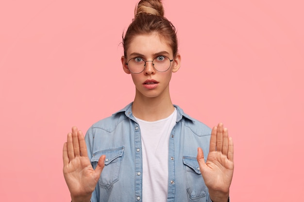 Ritratto di donna con i capelli in un panino e indossa una camicia di jeans