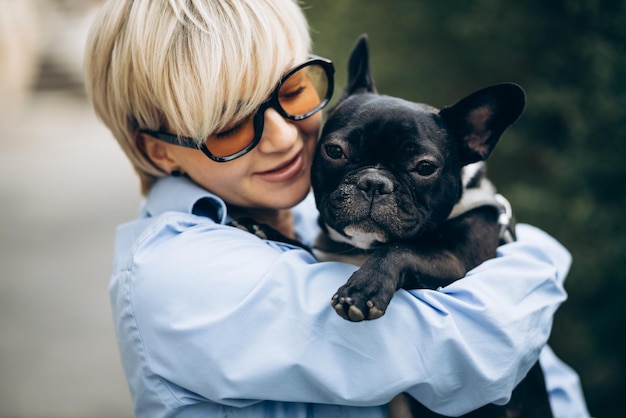 Ritratto di donna con il suo bulldog francese in un parco