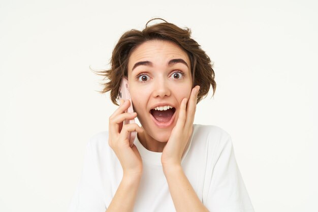 Ritratto di donna con il volto sorpreso risponde alla telefonata e sembra emozionato stupito dalle grandi edicole