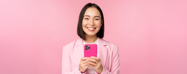 Ritratto di donna d'affari sorridente persona corporativa asiatica utilizzando l'applicazione smartphone cellulare