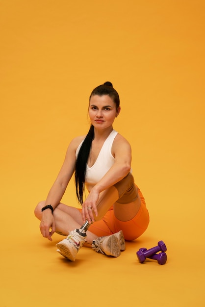 Ritratto di donna disabile con gamba protesica che si esercita con i pesi