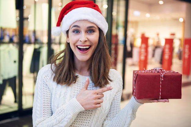 Ritratto di donna eccitata che punta al regalo di Natale