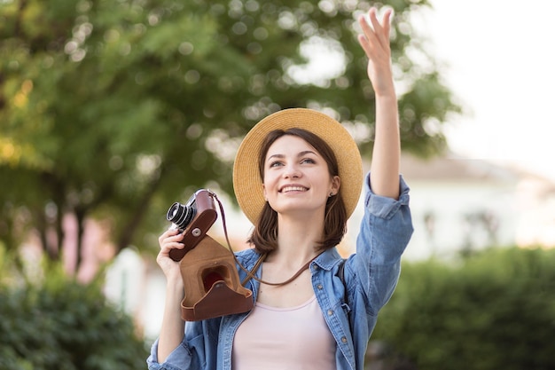 Ritratto di donna elegante con cappello e macchina fotografica