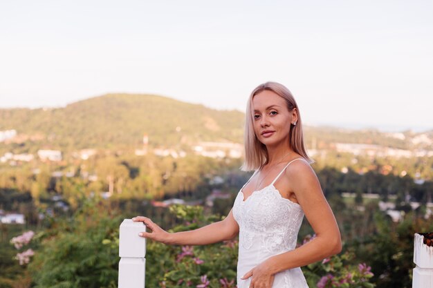 Ritratto di donna europea in abito da sposa che indossa collana e anello.