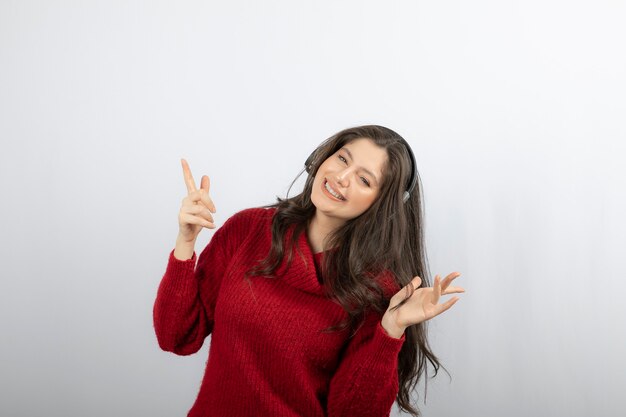 Ritratto di donna felicissima che ascolta musica con le cuffie.