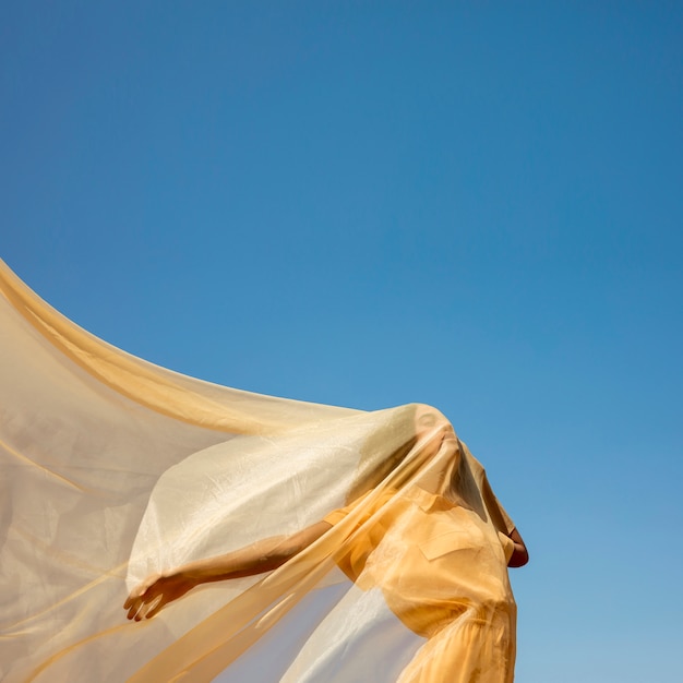 Ritratto di donna gioiosa con un panno giallo in natura