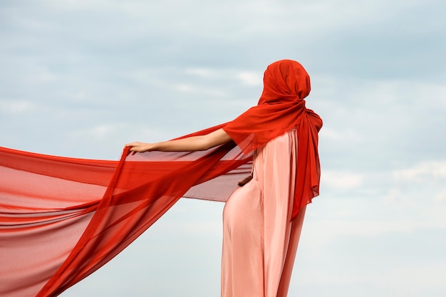 Ritratto di donna in spiaggia con il viso coperto da velo