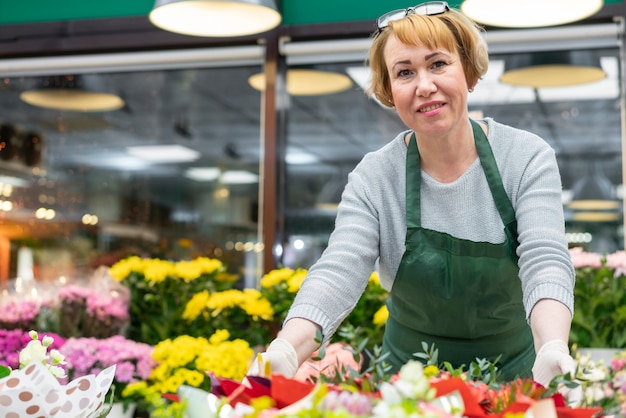 Ritratto di donna matura in posa con i fiori