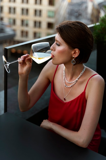 Ritratto di donna ricca che beve vino all'aperto