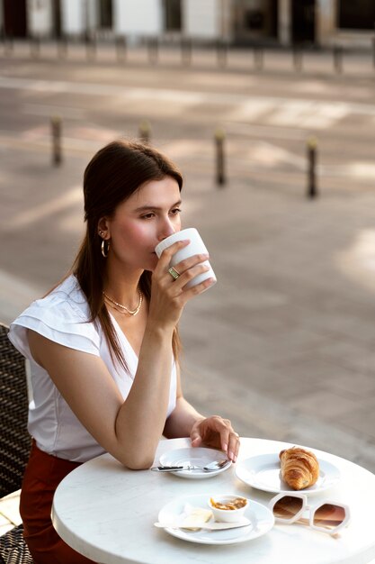 Ritratto di donna ricca che ha una pausa caffè