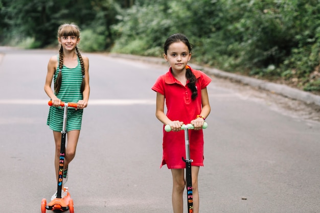 Ritratto di due amici femminili su scooter push