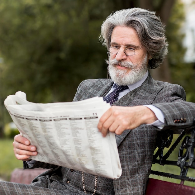 Ritratto di elegante maschio maturo leggendo il giornale