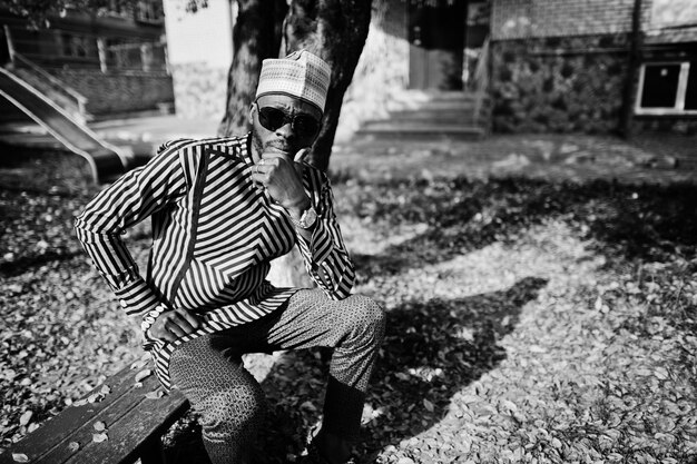 Ritratto di elegante uomo afroamericano nero con cappello e occhiali da sole su sfondo autunnale soleggiato Persone ricche in africa in abito tradizionale