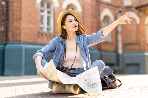 Ritratto di elegante viaggiatore con cappello e mappa