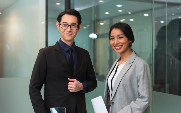 Ritratto di felice business team asiatico di colleghi di ufficio in piedi insieme nella sala del consiglio