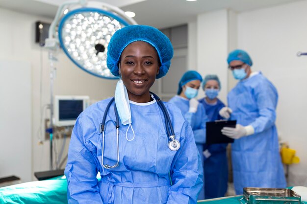 Ritratto di felice chirurgo donna afroamericana in piedi in sala operatoria pronta a lavorare su un paziente Operatrice medica in uniforme chirurgica in sala operatoria
