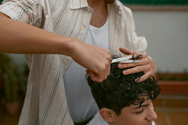 Ritratto di fratelli all'aperto durante una sessione di taglio di capelli