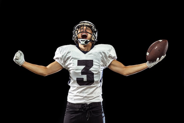 Ritratto di giocatore di football americano in attrezzatura sportiva isolato su nero